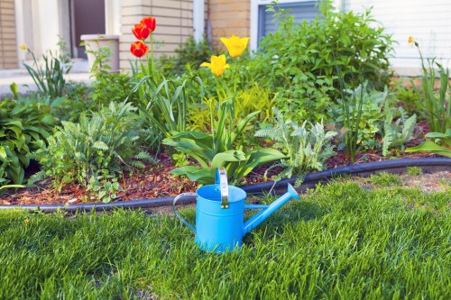 Gardener assessing a small front garden in Enfield Town for pricing